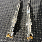 Two metal drill bits on a textured black and gray surface