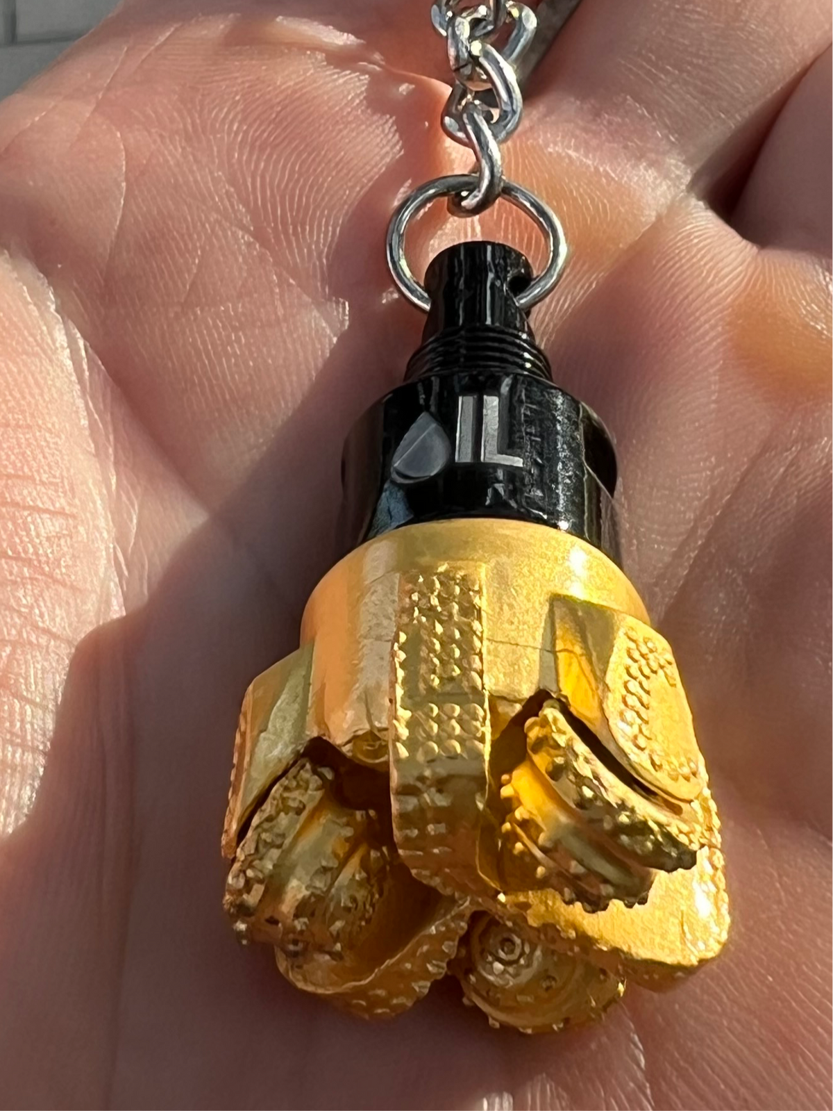 Oil drill bit keychain black and gold